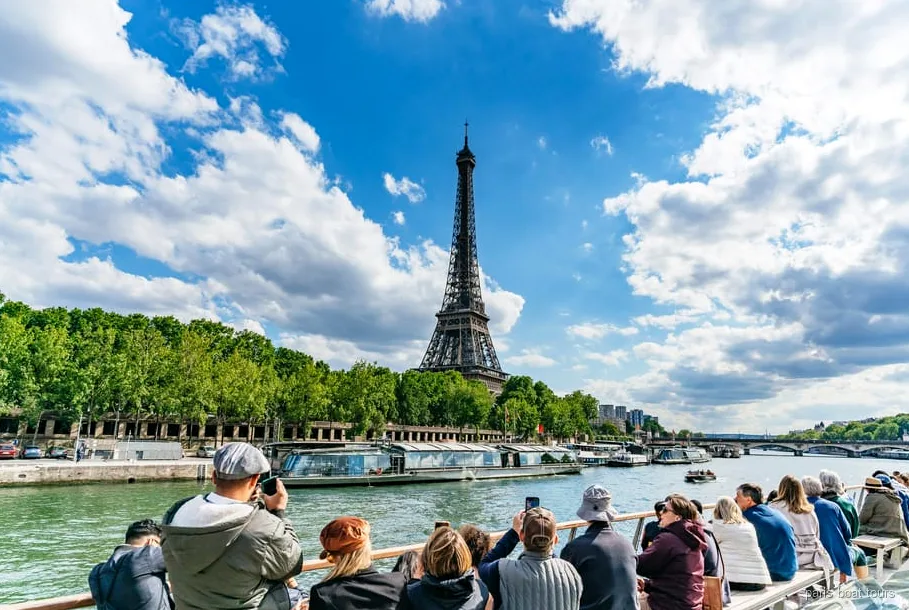 Bateau mouche naviguant devant la tour Eiffel à Paris