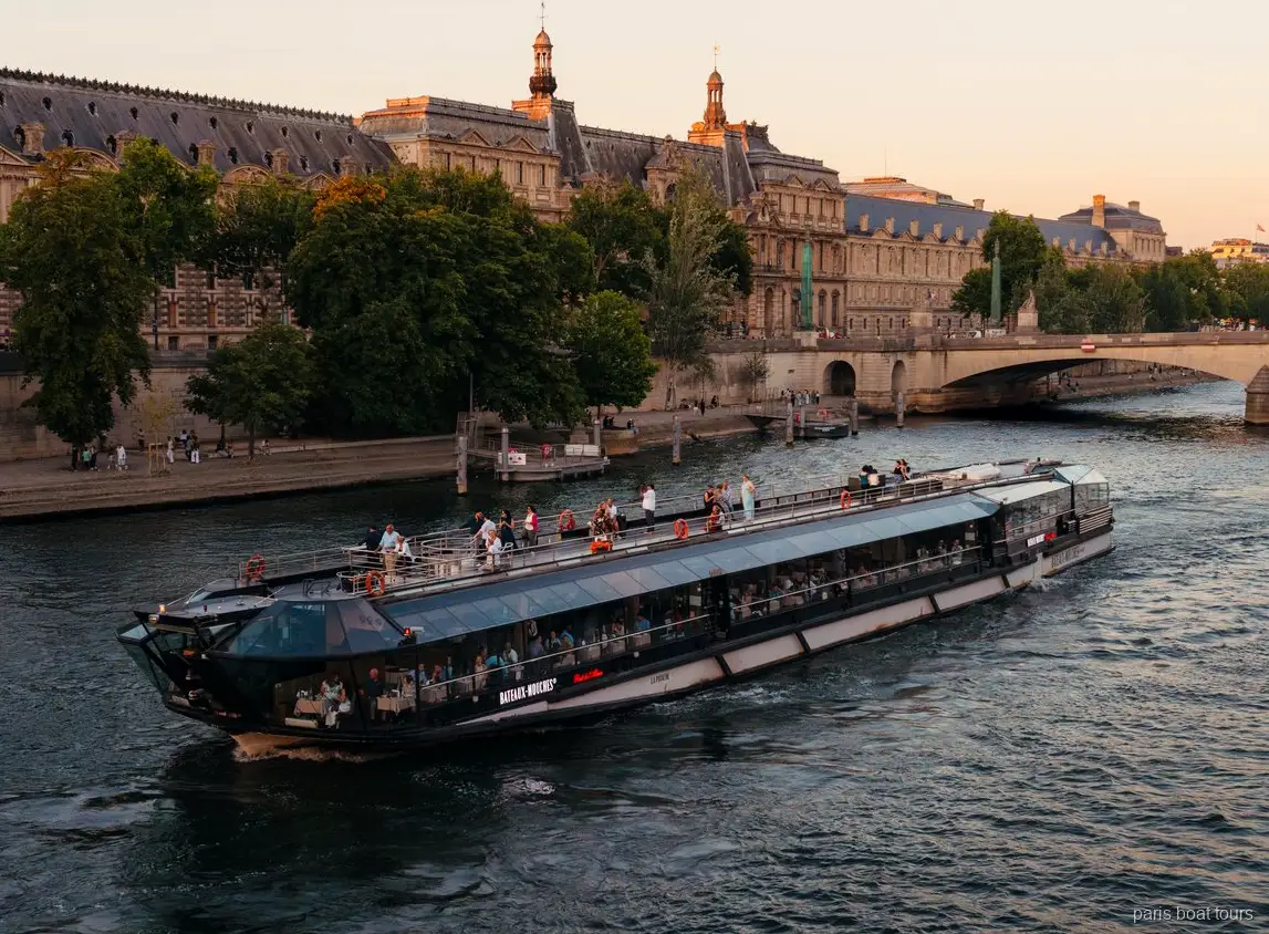 Battello Bateaux Mouches sulla Senna al crepuscolo davanti a edifici storici in pietra, tour in barca a Parigi