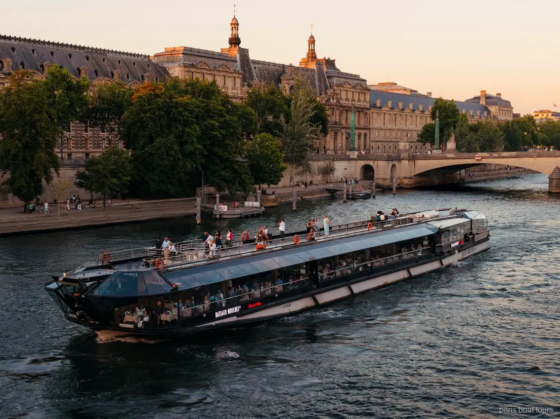 Barco Bateaux Mouches navegando por el Sena al anochecer junto a edificios históricos de piedra en un paseo en barco por París