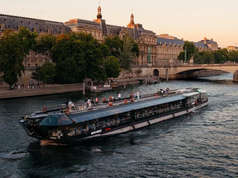Bateaux Mouches boot vaart in de schemering over de Seine langs historische stenen gebouwen, boottochten in Parijs