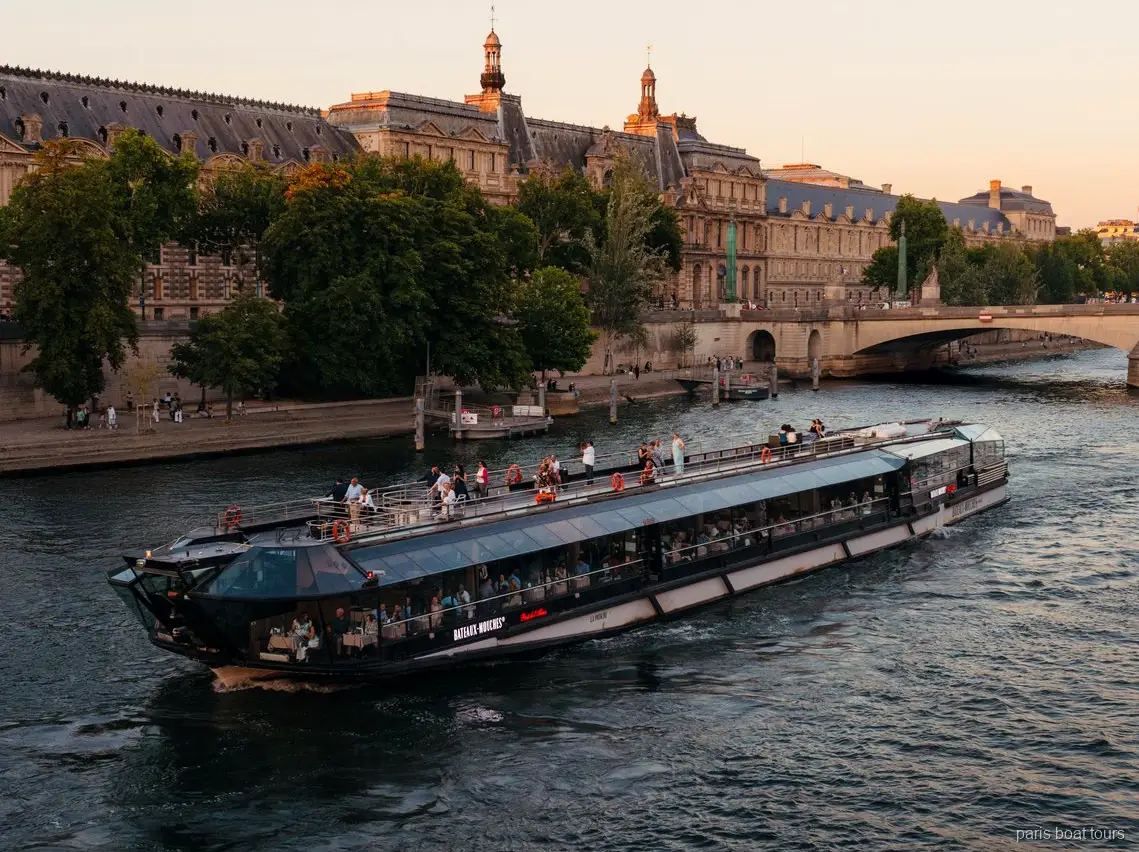 Bateaux Mouches Schiff gleitet in der Dämmerung an historischen Steingebäuden vorbei, Paris Bootstouren auf der Seine