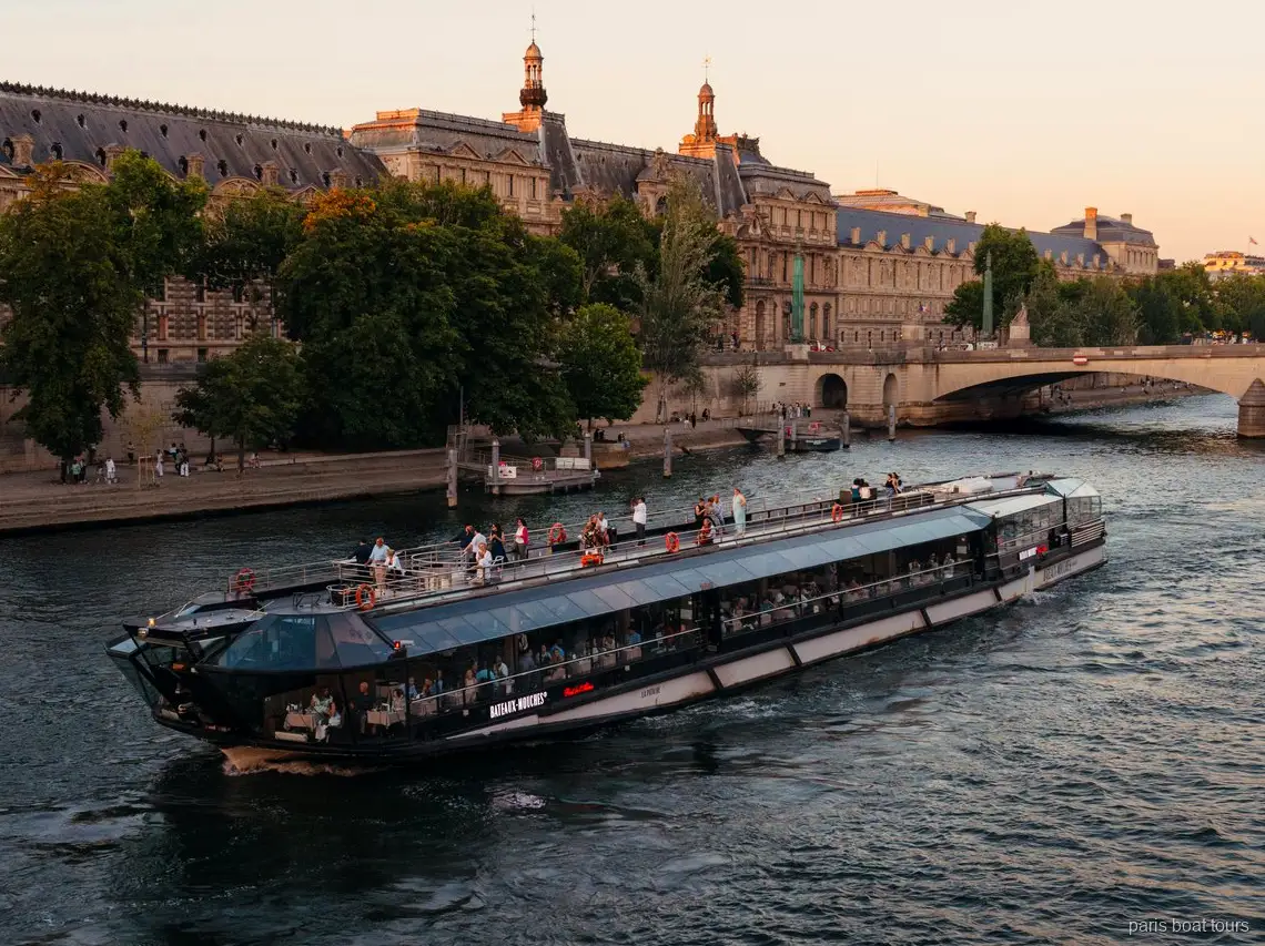 Bateaux Mouches-båt glider fram på Seine i skymningen förbi historiska stenbyggnader, båtturer i Paris