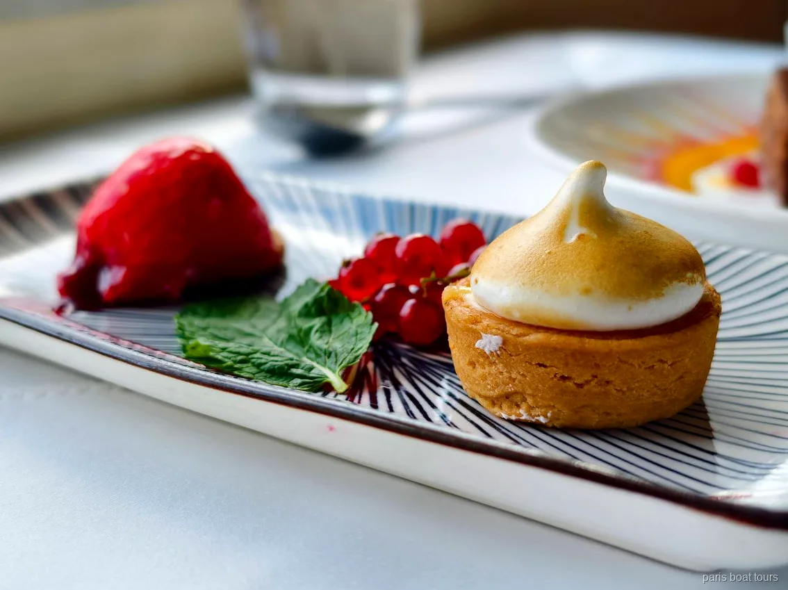 Dessert med en marengstærte, ribs, mynte og rød frugt på en sejltur i Paris