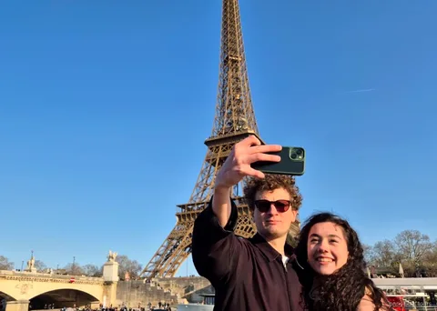 Coppia che si fa un selfie con la Torre Eiffel alle spalle in uno dei giri in barca a Parigi