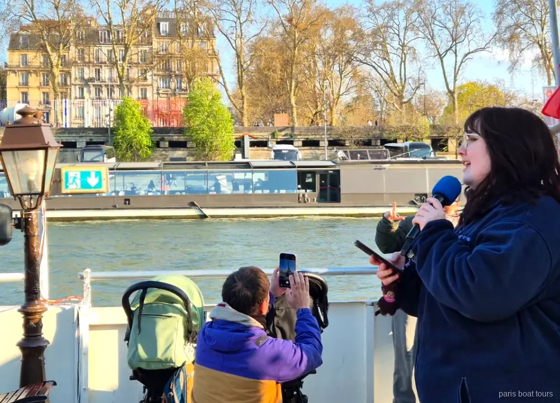 Guida con il microfono sul ponte mentre i passeggeri filmano il fiume, giri in barca a Parigi