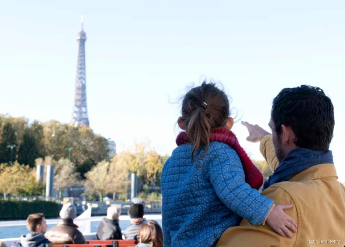 Adulto e bambino indicano la Torre Eiffel dal ponte di uno dei tour in barca a Parigi