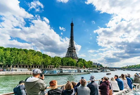 Battello da crociera sulla Senna che passa davanti alla Torre Eiffel a Parigi