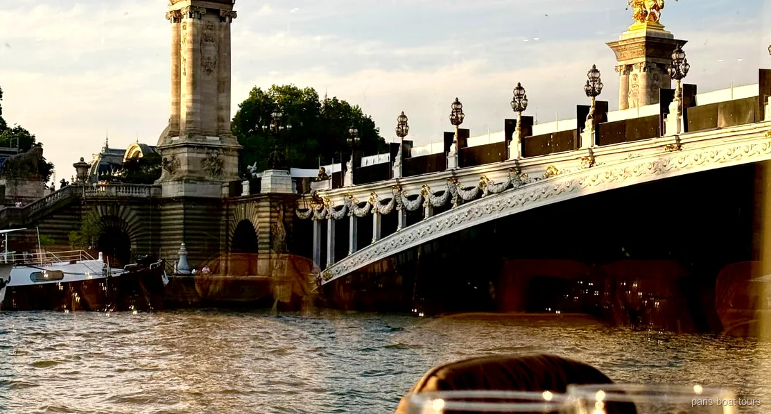 Barco del crucero con cena bistronomica por el Sena pasando junto a la Torre Eiffel iluminada