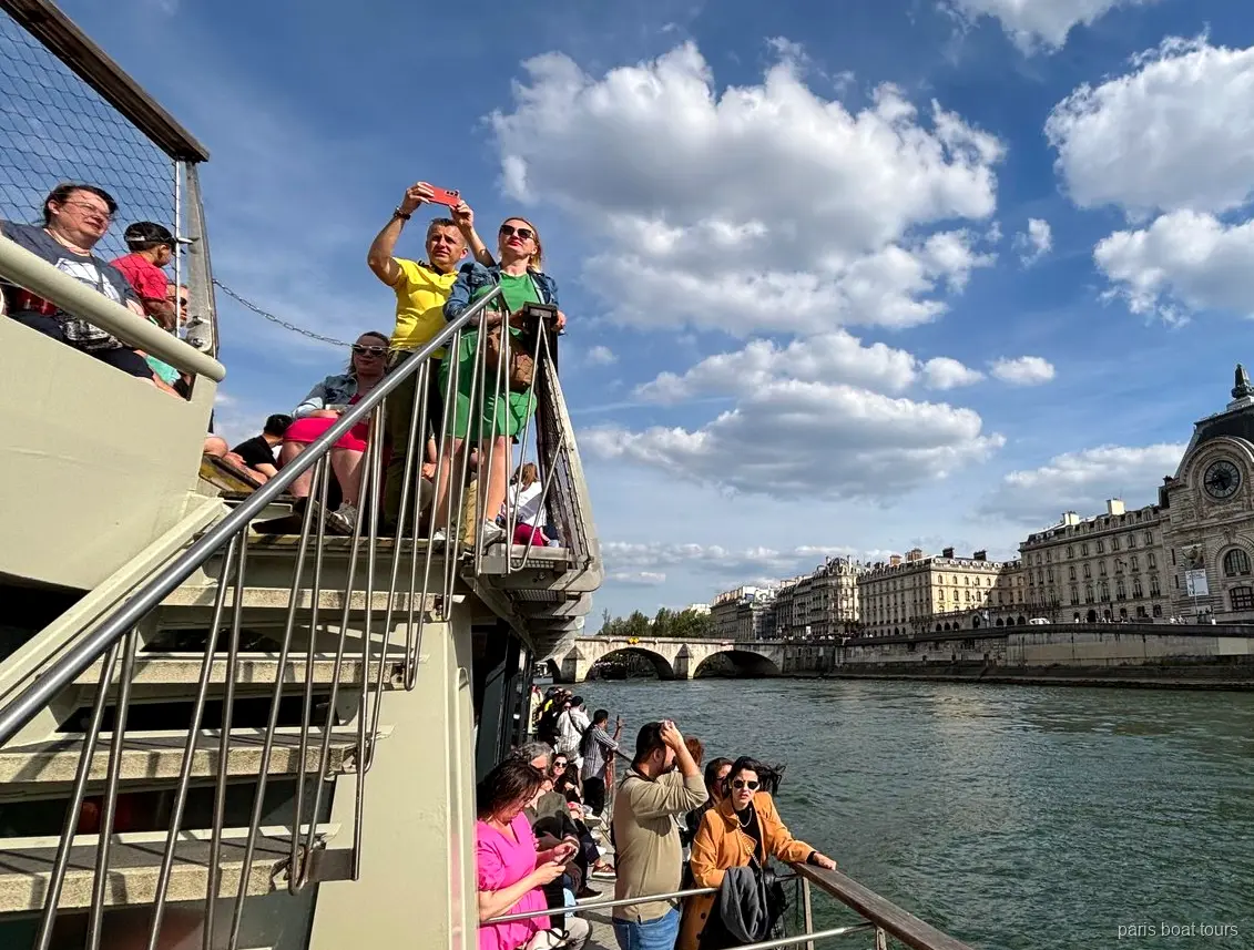 Passageiros no convés superior com o Musée d'Orsay na margem do Sena, passeios de barco em Paris