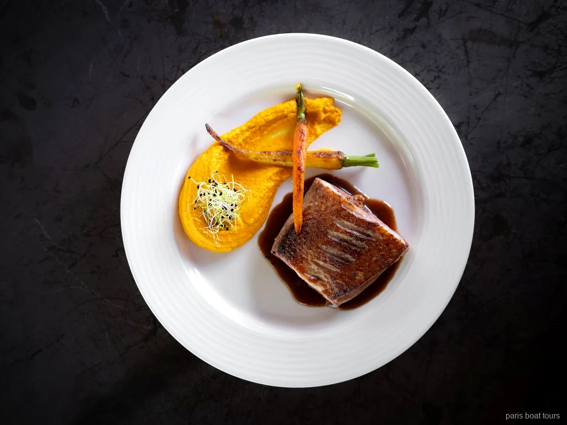Plat de viande poêlée avec purée de carottes et mini carottes au dîner Bateaux Mouches, croisières à Paris