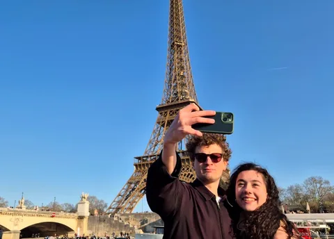 Par tar en selfie med Eiffeltornet bakom sig på en av båtturerna i Paris