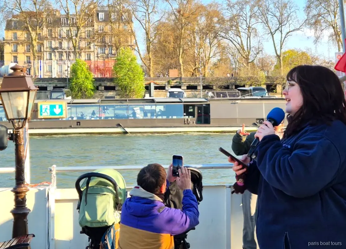 Guide talar i mikrofon på däck medan passagerare filmar floden, båtturer i Paris