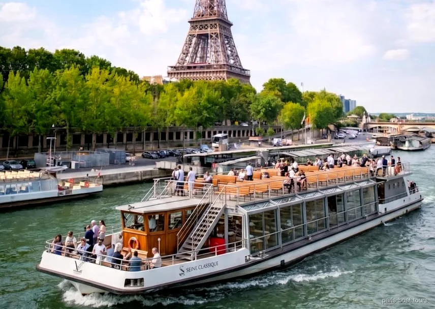 Barco del pase oficial del crucero por el Sena navegando junto a monumentos de Paris