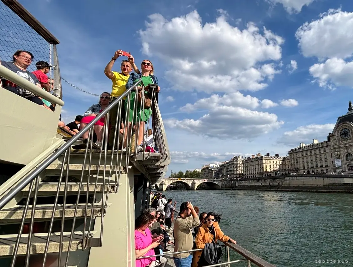 Pasażerowie na górnym pokładzie z Musée d'Orsay na brzegu Sekwany, rejsy po Paryżu