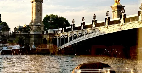 Seine River bistronomic dinner cruise boat passing the illuminated Eiffel Tower