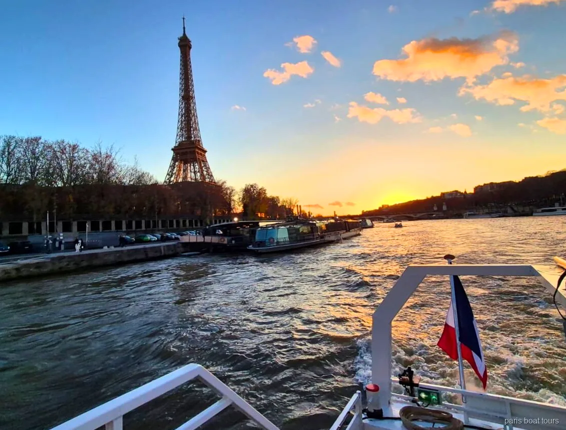 Paris tekne turunun kıç tarafından gün batımı gökyüzünde Eyfel Kulesi ve Fransız bayrağı