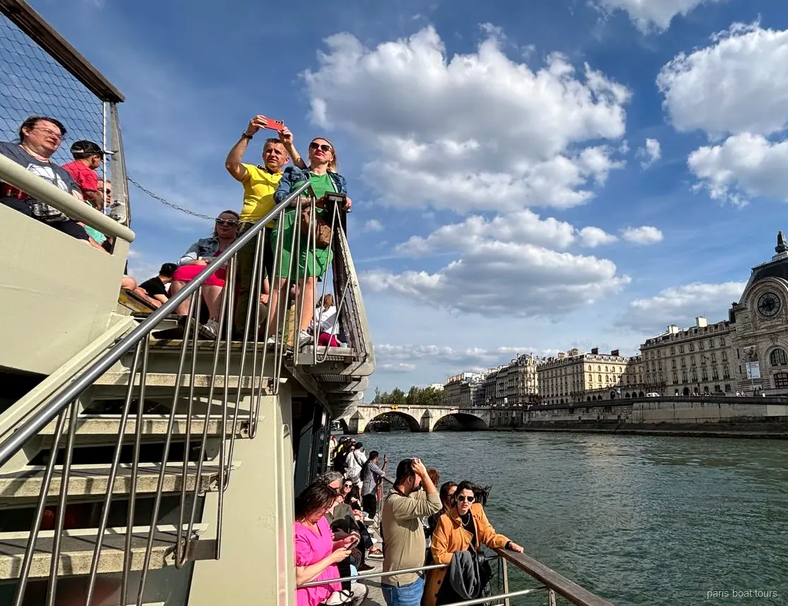 Passagerare på övre däck med Musée d'Orsay vid Seines strand, båtturer i Paris