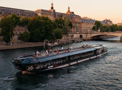 Vaixell Bateaux Mouches navegant pel Sena al capvespre davant d'edificis històrics en un creuer per París